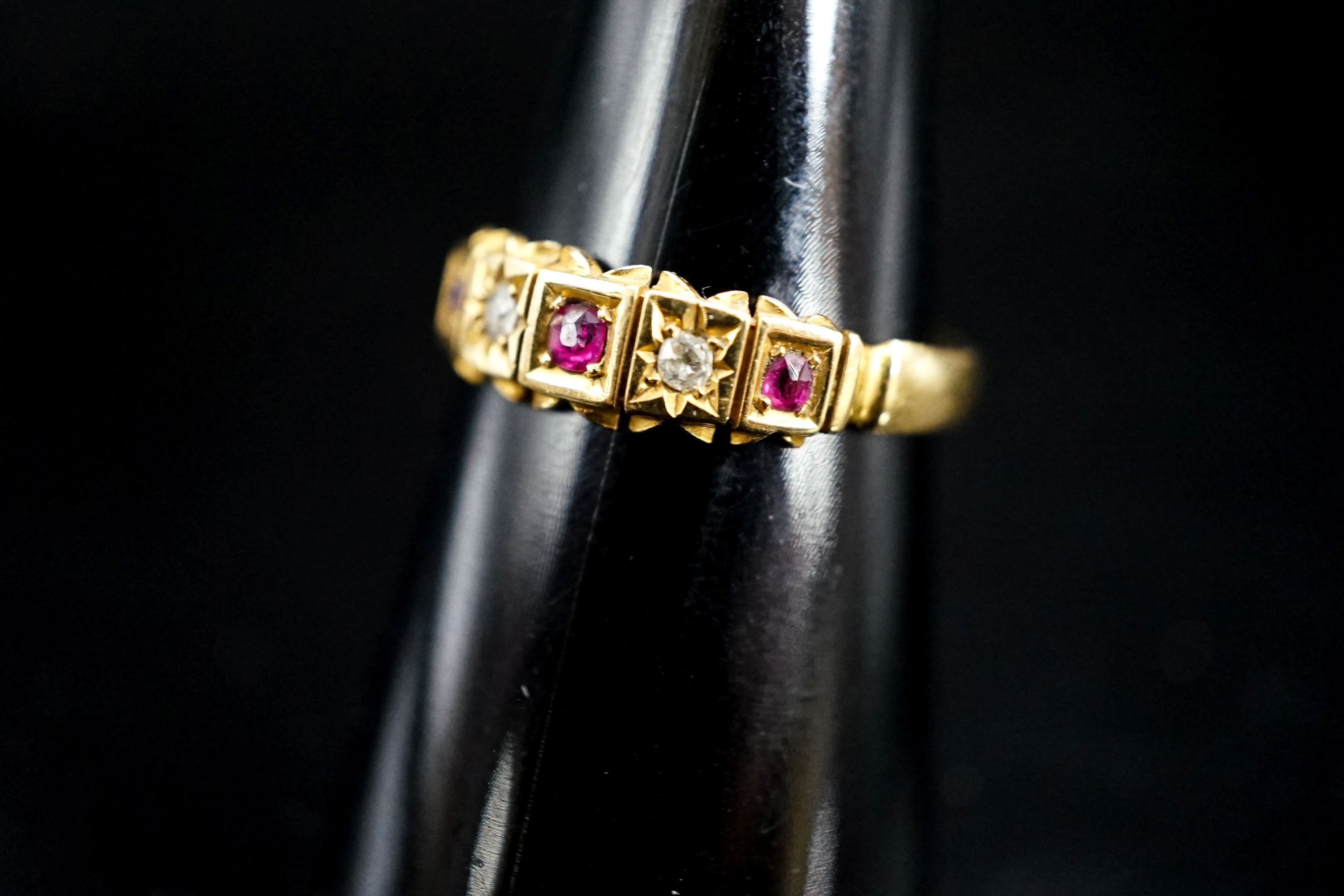 A late Victorian 18ct gold, ruby and diamond chip set half hoop ring, size O, gross 2.5 grams.